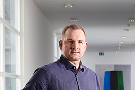 Zu sehen ist ein Profilbild von Prof. Dr. Tobias Hodel vor den leeren Hallen des Unitoblers